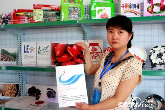 　　梁珏菲展示员工的网店设计作品。